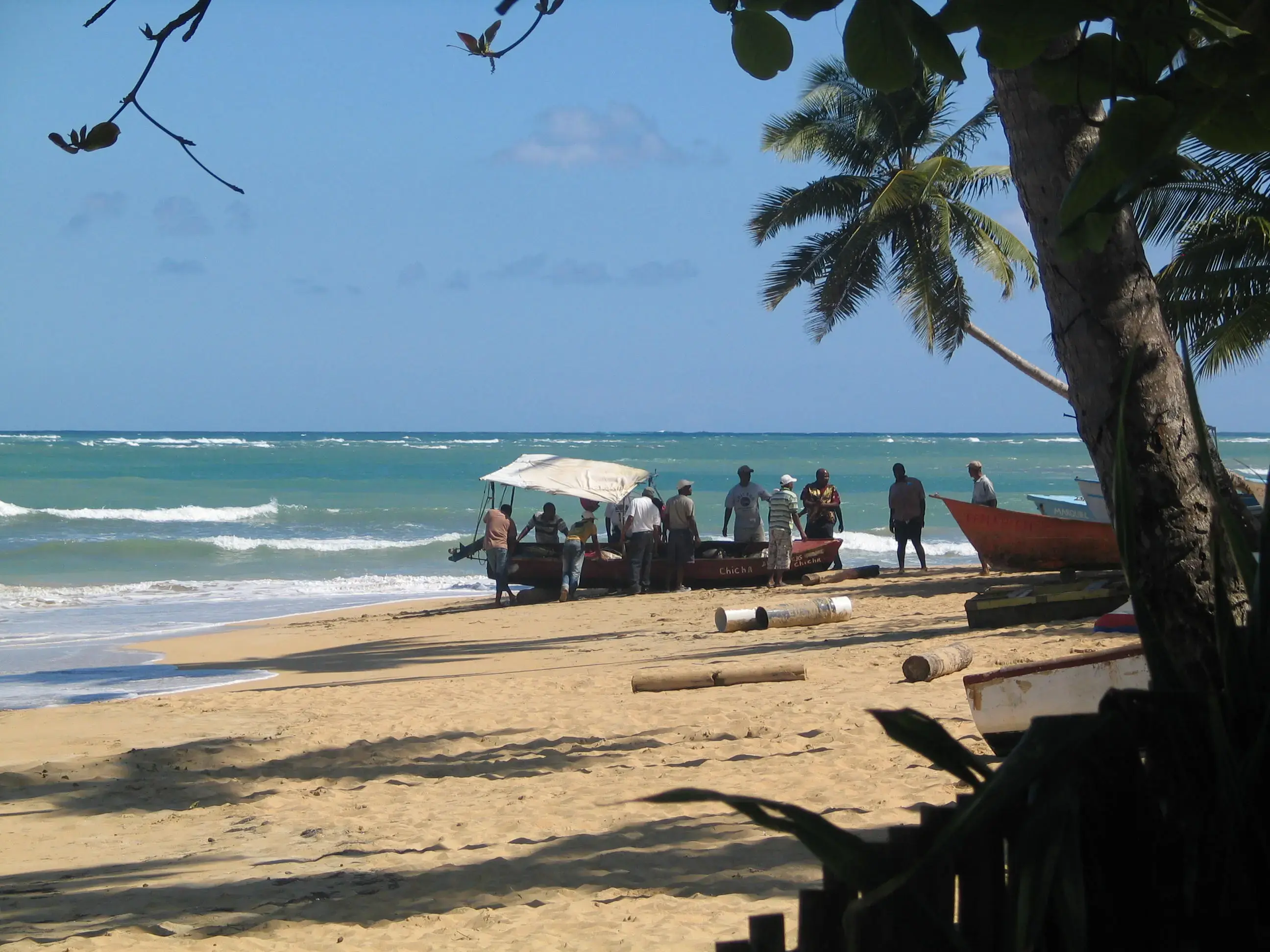 Local fishermen launching boats from the beach at Las Terrenas