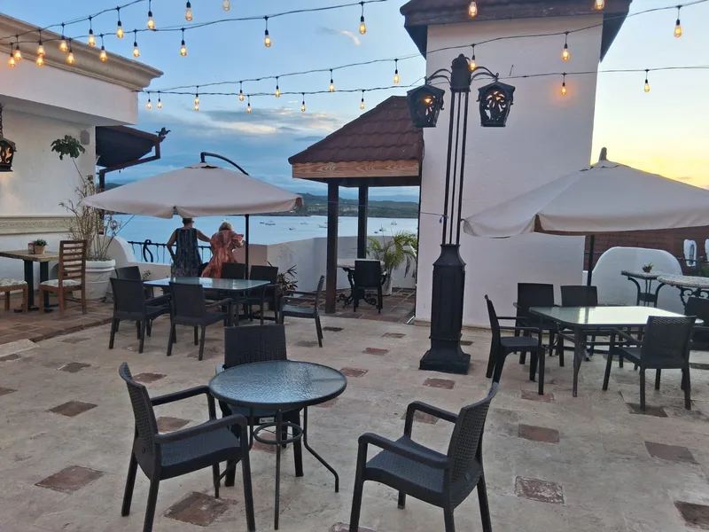Rooftop terrace at Leo's Banana at dusk, looking out over Sosúa Bay