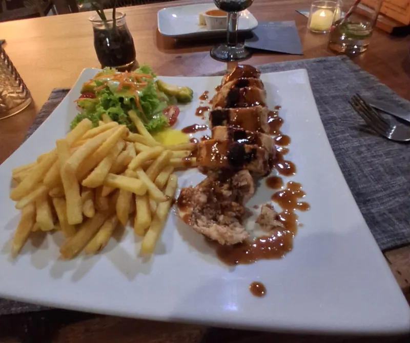 A dinner plate served with fries and salad at Natura Cabana