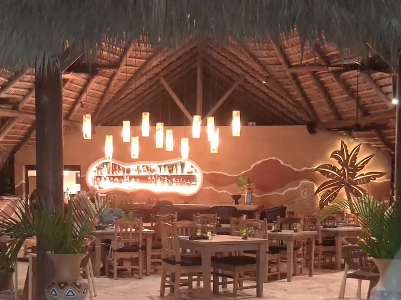 The thatched palapa restaurant at Natura Cabana, lit up at night